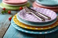 Stack of Colorful Polka Dot Plates with Cutlery on Rustic Table Royalty Free Stock Photo