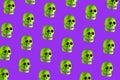 Vibrant image featuring a variety of green skulls with radiant red eyes on a purple background