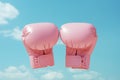 The vibrant image portrays a pair of pink boxing gloves suspended against a vivid blue sky. Symbols of strength, determination,