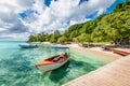 Small motorized boat at the pier and beach of Cayo Levantado Island, Samana Bay, Dominican Republic.