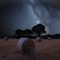 Vibrant Milky Way composite image over landscape of field of hay