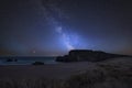 Vibrant Milky Way composite image over landscape of headland and ocean