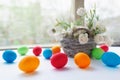 Vibrant multicolored Easter eggs on a white background with wicker basket with white flowers