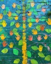 Vibrant mural of hands, leaves, and flowers on a brick wall in a green ecoregion Royalty Free Stock Photo