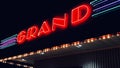 Vibrant neon sign for Grand Theaters in Bismarck, North Dakota illuminated against the night sky