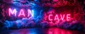 Vibrant neon sign spelling MAN CAVE on a brick wall backdrop enveloped in a mystical blue and red smoke, symbolizing a Royalty Free Stock Photo