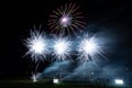 Vibrant night sky illuminated by an array of colorful fireworks bursting above a lake