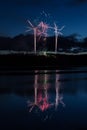 Vibrant night sky illuminated by an array of colorful fireworks bursting above a lake Royalty Free Stock Photo