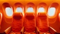 Vibrant Orange Airplane Seats Row of Comfortable Cushioned Seats in Modern Aircraft Cabin Against Blue Sky Royalty Free Stock Photo