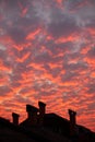 Vibrant orange clouds over rooftop chimneys Royalty Free Stock Photo