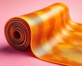 Rolled Amber-Colored Flexible Material on Pink Background Royalty Free Stock Photo