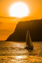 Vibrant orange ocean sunset with a sailboat