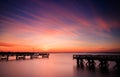 Vibrant orange and pink pastel color sunset over fishing piers. Perfectly still water Royalty Free Stock Photo