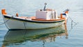 Vibrant orange and white boat in Adamas, Greece