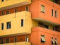 Vibrant orange and yellow exterior of a modern apartment building with multiple balconies Royalty Free Stock Photo