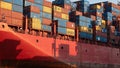 Vibrant painted container ship hull with colorful cargo containers casting long shadows Royalty Free Stock Photo