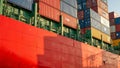 Vibrant painted container ship hull with colorful cargo containers casting long shadows Royalty Free Stock Photo
