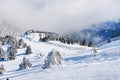Vibrant panorama of the slope at ski resort Kopaonik, Serbia, snow trees, fog Royalty Free Stock Photo