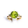 A vibrant peridot gemstone graces the center of a glossy, tarnish-resistant, yellow gold ring. The ring is accented with multiple