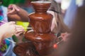 Vibrant Picture of Chocolate Fountain Fontain on childen kids birthday party with a kids playing around and marshmallows and fruit