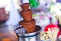 Vibrant Picture of Chocolate Fountain Fontain on childen kids birthday party with a kids playing around and marshmallows and fruit Royalty Free Stock Photo