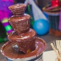 Vibrant Picture of Chocolate Fountain Fontain on childen kids birthday party with a kids playing around and marshmallows and fruit