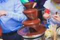 Vibrant Picture of Chocolate Fountain Fontain on childen kids birthday party with a kids playing around and marshmallows and fruit Royalty Free Stock Photo