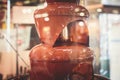 Vibrant Picture of Chocolate Fountain Fontain on childen kids birthday party with a kids playing around and marshmallows and fruit