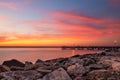 Vibrant sunset over a fishing pier and rock jetty. Jones Beach New York.