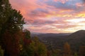 Vibrant colors of the sunrise and changing colors of the fall trees with endless mountains