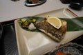 Vibrant plate of a grilled fish served with a side of lemon slices and white rice