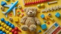 Colorful Baby Toy Collection with Teddy Bear, Abacus, Musical & Fidget Toys and Blocks on Yellow Background - Top View Flat Lay