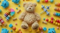 Colorful Baby Toy Collection with Teddy Bear, Abacus, Musical & Fidget Toys and Blocks on Yellow Background - Top View Flat Lay