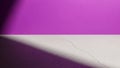 Vibrant purple wall meets cracked concrete floor with dramatic light shadow Royalty Free Stock Photo