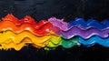 A vibrant rainbow of thick paint strokes on a textured black background in a wavy pattern design Royalty Free Stock Photo