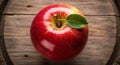 A vibrant red apple with a smooth, glossy surface rests on a rustic wooden barrel. The apple Royalty Free Stock Photo