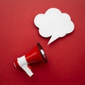 Red background with cloud speech bubble and megaphone, suggesting communication Royalty Free Stock Photo