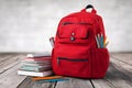 Vibrant Red Backpack with School Supplies Including Notebooks and Pencils on Wooden Surface Royalty Free Stock Photo