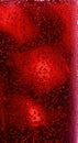 A vibrant red carbonated beverage with numerous effervescent bubbles and glowing ice cubes creates a refreshing, cool, and Royalty Free Stock Photo