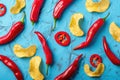 Vibrant Red Chili Peppers and Potato Chips on Turquoise Surface Royalty Free Stock Photo