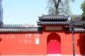 Vibrant red doorway with the black roof of the Pilu temple in China