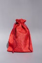 Vibrant red drawstring bag with textured fabric on gray background Royalty Free Stock Photo