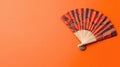 vibrant red fan with intricate black dragon patterns on orange background Royalty Free Stock Photo