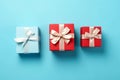 Vibrant red gift box decorated with white satin ribbon and bow, against a pastel blue backdrop Royalty Free Stock Photo