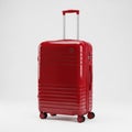 Shiny Red Hardside Rolling Suitcase with Telescopic Handle and Four Wheels on a White Background Royalty Free Stock Photo