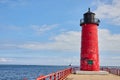 Vibrant Red Lighthouse on Milwaukee Pier with Sailboat Royalty Free Stock Photo