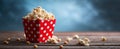 The vibrant red popcorn box overflowing with delicious popcorn on a wooden table..AI generated image Royalty Free Stock Photo