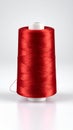Vibrant red thread spool on a white background, ideal for sewing, embroidery, and textile crafts. Royalty Free Stock Photo