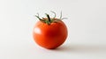 A vibrant red tomato with a smooth surface placed on a clean white background in a studio close-up Royalty Free Stock Photo