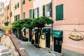 Vibrant residential street with a variety of colorful houses lining the sidewalk in Genoa, Italy.